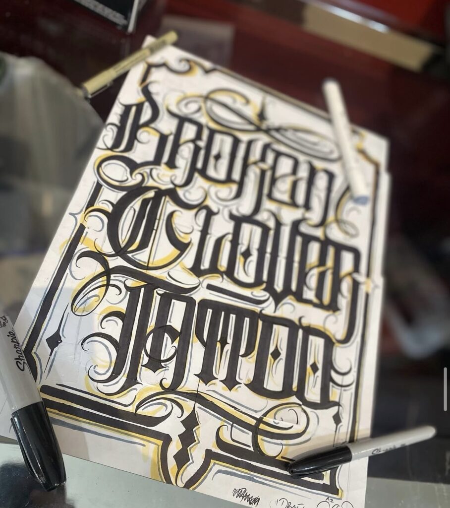 Sheet of hand-drawn Chicano and blackletter tattoo designs by Jay