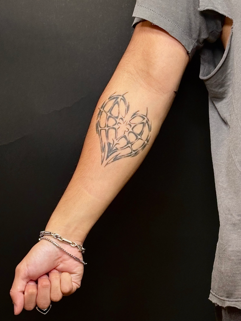 Heart design done on inner forearm with fine line and minimal shading