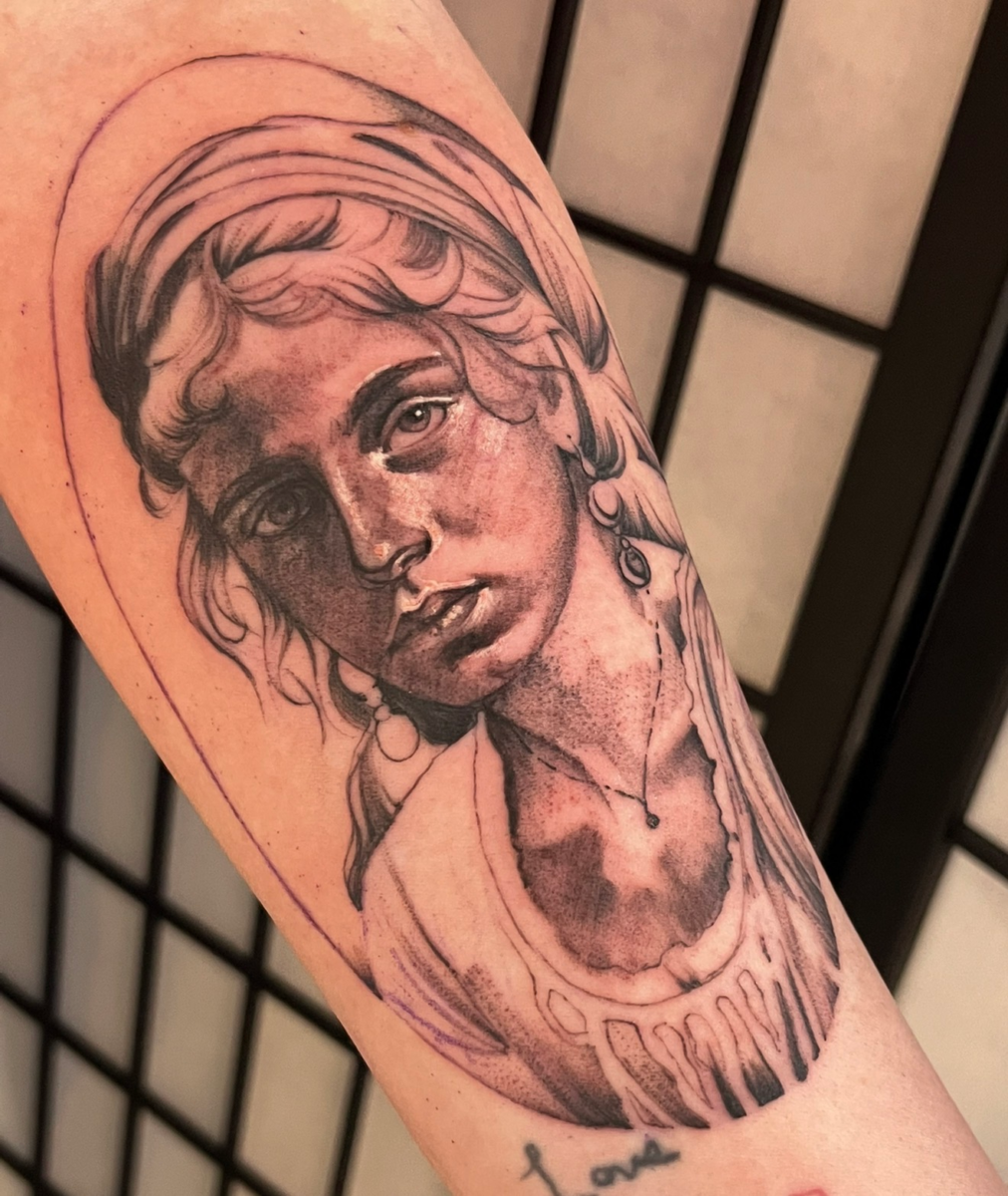 Black-and-grey portrait tattoo of a young woman by Jinx at Broken Clover Tattoo in Tucson